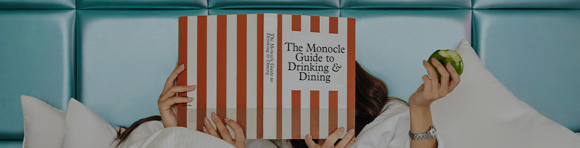 guests in bed reading a book